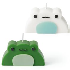 two green and white objects with faces on them, one is shaped like a cat