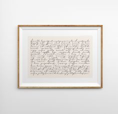 an old handwriting is hanging on the wall in front of a white wall with a wooden frame