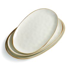 three white and gold plates stacked on top of each other, with one empty plate in the middle