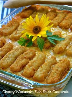 a casserole dish with fish sticks and a yellow flower