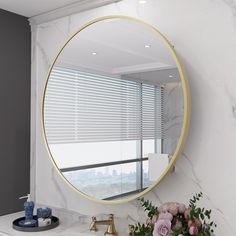 a bathroom sink with a round mirror above it and flowers in front of the window