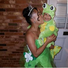 a woman holding a child dressed as a frog