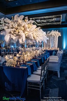 a table with blue linens and white flowers is set up for a formal function