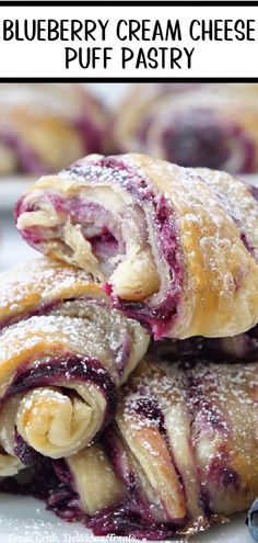 Three blueberry puff pastries dusted with powdered sugar on a plate with a bite taken out of the top one. Blueberry Cream Cheese Puff Pastry, Blueberry Puff Pastry, Sweet Puff Pastry Recipes, Cream Cheese Puffs, Easy Puff Pastry Recipe, Puff Pastry Recipes Dessert, Pastry Dough Recipe, Cream Cheese Puff Pastry, Puff Dessert