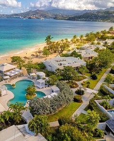 an aerial view of the beach and resort with swimming pool in foreground, surrounded by palm trees