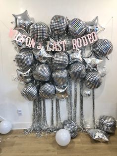 a bunch of balloons that are in the shape of disco balls with words on them