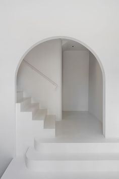 an empty room with white walls and stairs