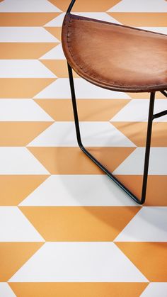 an orange and white tiled floor with a wooden chair on the bottom right hand side