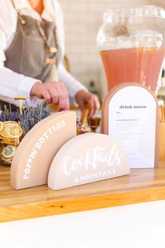 a person standing at a counter making drinks