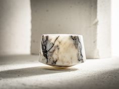 a marble ring sitting on top of a white floor next to a cement block wall