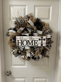 a welcome wreath with the words welcome to the home on it in front of a door