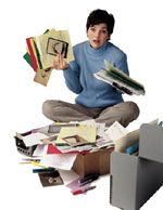 a person sitting on the floor with papers and folders in front of him, surrounded by files