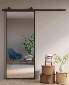 an empty room with two chairs and a large mirror on the wall next to a potted plant