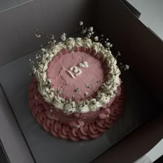 a pink cake with white frosting in a box