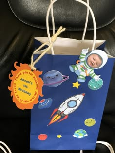 a small blue gift bag with an image of a baby in space on the front