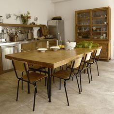 a wooden table sitting in the middle of a kitchen