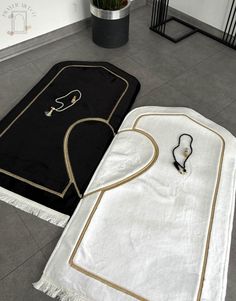 two black and white rugs on the floor with one laying down next to it