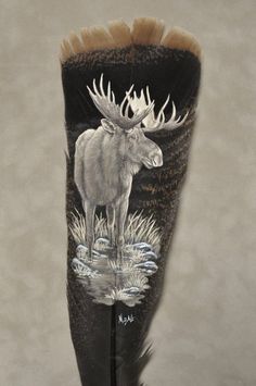 a black boot with a moose painted on the side and feathers sticking out of it