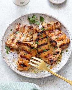 grilled chicken on a plate with a fork