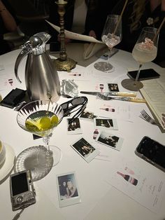 the table is cluttered with photos, wine glasses, and other personal items on it