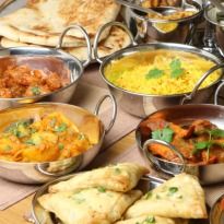 a table filled with lots of different types of food and silver bowls on it's sides