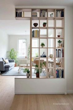 a living room filled with furniture and bookshelves next to a wall mounted book shelf