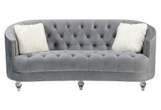 a gray couch with two white pillows on it's arms and legs, sitting against a white background