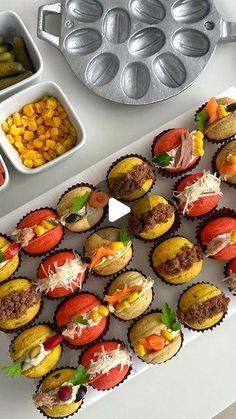 cupcakes are arranged on a tray next to other desserts and condiments