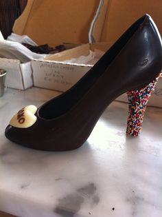 a chocolate shoe with sprinkles on the side and a heart in the middle