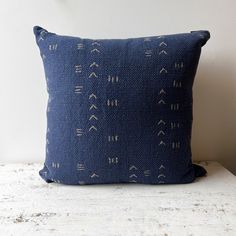 a blue pillow sitting on top of a white table