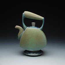 a ceramic tea pot with a handle on it