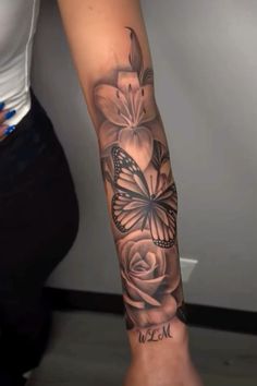 a woman's arm with flowers and a butterfly on it