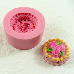 a pink plastic container with flowers on it next to a flower shaped cookie mold that is sitting on a white surface