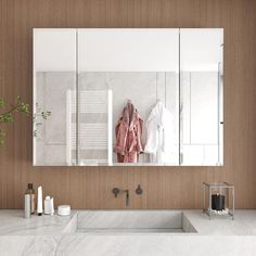 a bathroom with marble counter tops and white walls, along with a large mirror on the wall