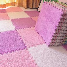 a pink and white rug on the floor next to a plant in a room with yellow curtains