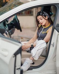 a woman sitting in the driver's seat of a car