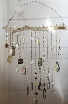 a wind chime hanging from a wooden branch filled with beads and other things on it