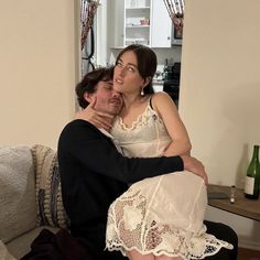 a man sitting next to a woman on top of a couch