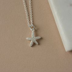 Sterling Silver Starfish Necklace - Beachy Necklace for Women -  Ocean Inspired Summer Jewelry This necklace has a delightful ocean-inspired theme that's perfect for summer. It features a charming sterling silver starfish charm with intricate detailing and a realistic texture down to the dotted pattern. The charm is one-sided (the back view is shown in the second-to-last image) and it measures 13mm wide and 16mm long (excluding the loop). The charm slides freely along sterling silver rolo chain, Cheap Silver Beaded Necklaces For Beach, Dainty Starfish Necklace For Beach, Ocean-inspired Strand Charm Necklaces As Gift, Ocean-inspired Necklaces With Star Charm, Starfish-shaped Necklace With Starfish Charm For Summer, Summer Starfish Charm Star Necklace, Star-shaped Ocean-inspired Necklaces For Beach, Ocean Color Necklace With Starfish Charm For Gift, Ocean-inspired Strand Necklace With Starfish Charm