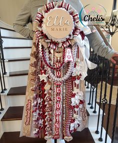 a woman standing next to some stairs wearing a dress made out of letters and ribbons