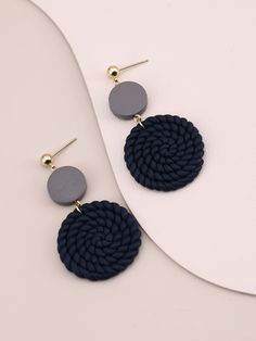 the navy and grey circular earrings are shown on a white surface