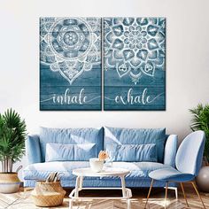 two blue couches sitting next to each other in front of a white wall with the word