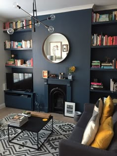 a living room filled with furniture and a fire place in front of a tv mounted on a wall