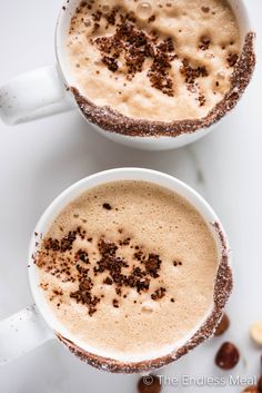 two mugs filled with nutella latte on top of a table