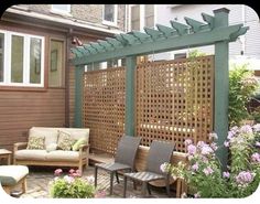 an outdoor living area with seating and pergolated screens on the side of a house