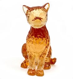 a glass cat figurine sitting on top of a white surface