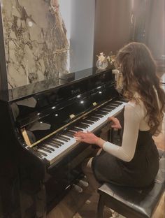 a woman sitting at a piano playing it