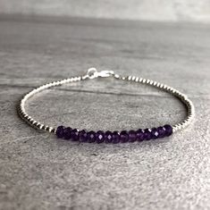 This delicate bracelet features small natural Amethyst gemstones. The faceted Amethyst beads are a beautiful vibrant purple hue. This piece is timeless, yet unique. A perfect gift for a birthday or for your Valentine. The tiny round beads frame the faceted gemstones beautifully. At checkout, choose to buy a Amethyst bracelet with gold or sterling silver beads. * METAPHYSICAL PROPERTIES OF AMETHYST * balance courage peace protection temperance wisdom Free gift with each crystal jewelry purchase f Amethyst Beaded Bracelets With Spacer Beads As Gift, Everyday Purple Hand-strung Jewelry, Amethyst Beaded Bracelet, Diamond Carat Size, Shiny Bracelets, Amethyst Bracelet Beads, Mini Bracelet, Diamond Bracelet Design, Classic Bracelets