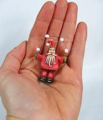 a hand holding a small red and white figurine in it's palm