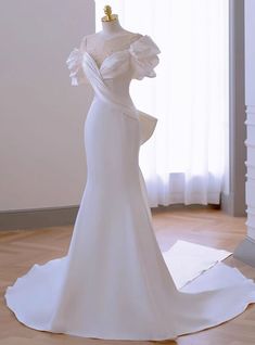 a white wedding dress on display in a room